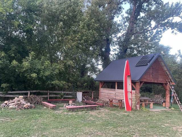 Czerwony kajak przy altanie Kajakiem po Rabie, palenisko na bazie